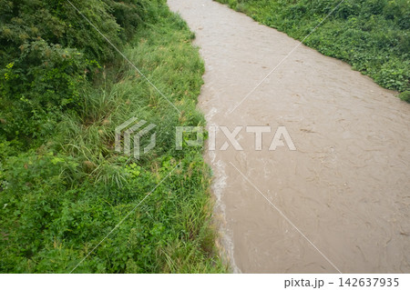 大雨で増水した濁った川の流れ 大雨で増水した濁った川の流れ 142637935
