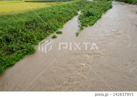 大雨で増水した濁った川の流れ 大雨で増水した濁った川の流れ 142637955
