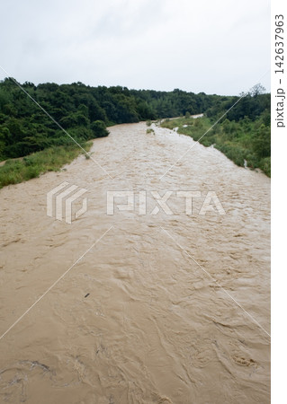 大雨で増水した濁った川の流れ 大雨で増水した濁った川の流れ 142637963