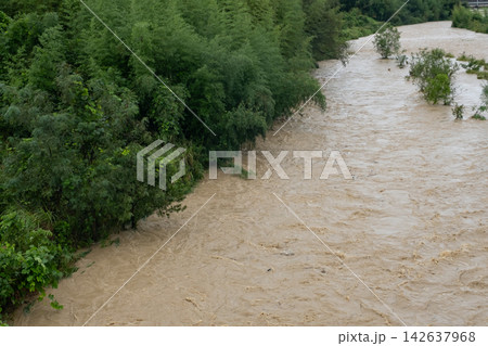 大雨で増水した濁った川の流れ 大雨で増水した濁った川の流れ 142637968