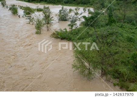大雨で増水した濁った川の流れ 大雨で増水した濁った川の流れ 142637970