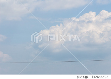 横切る電線と青空に湧き立つ大きな白雲と夏空 142638392
