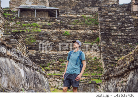 Man traveler exploring ancient stone structures at Tonina Maya ruins in Chiapas Mexico with pre Hispanic history stone walls cultural heritage Mexican archaeology and smiling. 142638436