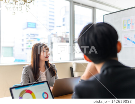 明るいオフィスで会話するビジネスパーソン 明るいオフィスで会話するビジネスパーソン 142639058
