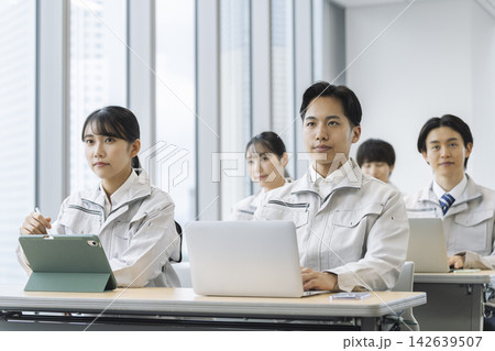 セミナーを受ける作業服の若い男女 セミナーを受ける作業服の若い男女 142639507