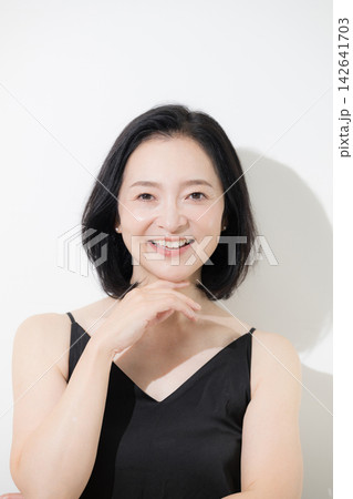 美しいツヤ肌と自然な表情が印象的な50代女性のビューティーカメラ目線の笑顔　スキンケアとエイジングケ 142641703