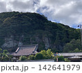 山の緑と岩肌を背景にした日本の寺院と瓦屋根 142641979