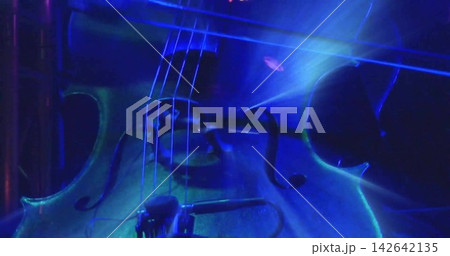 Lighting cue starting wooden cello body gleaming under blue teal stage lights, showing f-holes Lighting cue starting wooden cello body gleaming under blue teal stage lights, showing f-holes 142642135