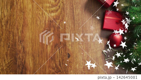 Showing cluster sitting on warm wood table with pine-sprig, red gifts, bauble, stars, copy space 142645081