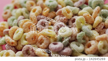 Showing pile of pastel cereal rings on table with sugary coating, numeric overlays, pink backdrop 142645269