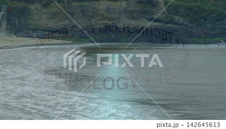 Showing water reflecting shoreline, cliff, reversed TECH overlay, figure right in dark jacket,pants 142645613