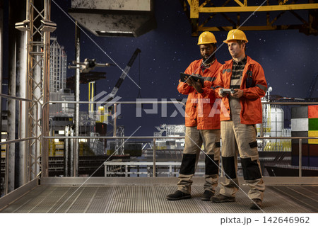 Professional drone operators flies a UAV around a drilling rig, using remote control and camera systems to evaluate the condition and ensure safety on platform, oil production. Professional drone operators flies a UAV around a drilling rig, using remote control and camera systems to evaluate the condition and ensure safety on platform, oil production. 142646962
