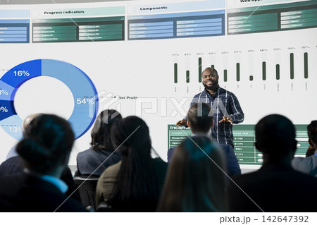Black male speaker hosting a presentation at international conference event in auditorium, giving a speech for networking and startup development. Investment or partnership opportunities. Black male speaker hosting a presentation at international conference event in auditorium, giving a speech for networking and startup development. Investment or partnership opportunities. 142647392