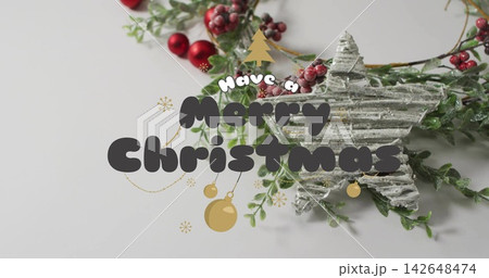 Displaying corrugated star, frosted wreath and red berries on pale grey table, Merry Christmas text 142648474