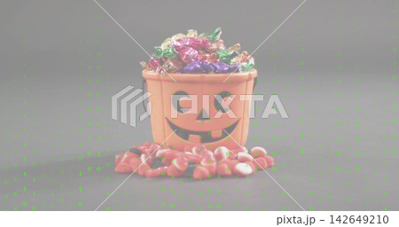 Showing orange pumpkin bucket sitting on studio table brimming foil treats candy corn green spots 142649210