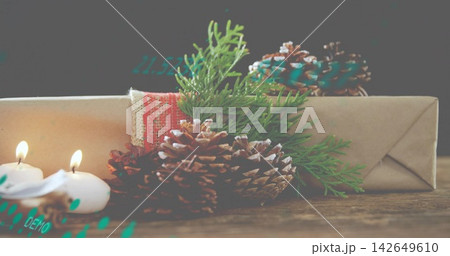 Displaying rustic wrapped parcel with red lace on wooden tabletop, with pinecones and lit tealights Displaying rustic wrapped parcel with red lace on wooden tabletop, with pinecones and lit tealights 142649610