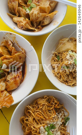 Yellow table holds four bowls of food 142649946