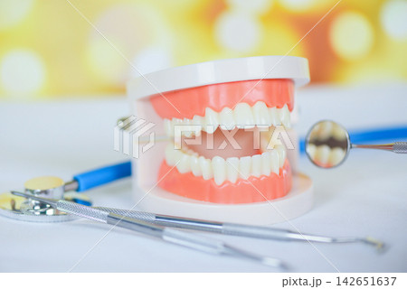 dentist tools with dentures dentistry instruments and dental hygienist checkup concept with teeth model and mouth mirror oral health stethoscope doctor dentist tools with dentures dentistry instruments and dental hygienist checkup concept with teeth model and mouth mirror oral health stethoscope doctor 142651637