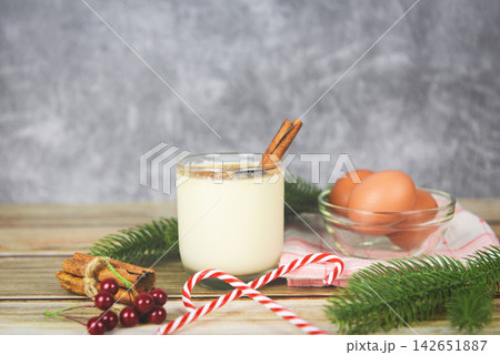 Eggnog delicious holiday drinks like themed parties with cinnamon and nutmeg for Traditional Christmas and winter holidays Homemade eggnog in glasses and fresh eggs decorated Eggnog delicious holiday drinks like themed parties with cinnamon and nutmeg for Traditional Christmas and winter holidays Homemade eggnog in glasses and fresh eggs decorated 142651887