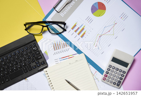 Financial and business graph chart report paper document with calculator open notebook paper Financial and business graph chart report paper document with calculator open notebook paper 142651957