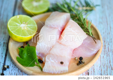 Fish fillet on wooden plate with ingredients celery for cookin, fresh raw pangasius fish fillet with lemon lime, meat dolly fish tilapia striped catfish 142651965