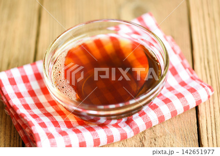 fish sauce on glass bowl and wooden background, fish sauce obtained from fermentation fish or small aquatic animal, fermented foods fish sauce on glass bowl and wooden background, fish sauce obtained from fermentation fish or small aquatic animal, fermented foods 142651977