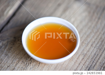fish sauce on white bowl on wooden background, fish sauce obtained from fermentation fish or small aquatic animal, fermented foods fish sauce on white bowl on wooden background, fish sauce obtained from fermentation fish or small aquatic animal, fermented foods 142651981
