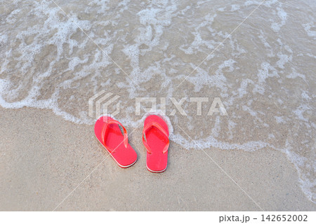 flip flops on beach with wave sandy beach sea at the ocean 142652002