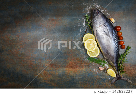 Fresh fish with herbs spices rosemary tomato and lemon - Raw fish seafood on black plate background , Longtail tuna , Eastern little tuna fish 142652227