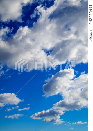 a fluffy cumulus cloud illuminated by sunlight against a bright blue sky a fluffy cumulus cloud illuminated by sunlight against a bright blue sky 142653991