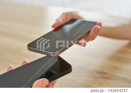 2台のスマートフォンを近づける手元 2台のスマートフォンを近づける手元 142654257
