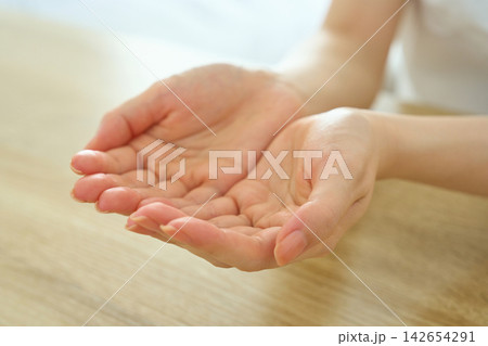 両手ですくうジェスチャーをする若い女性 両手ですくうジェスチャーをする若い女性 142654291