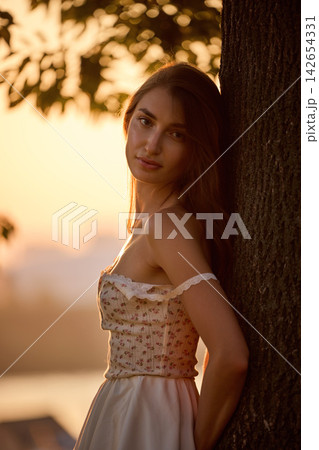 Slavic Woman in Lace Dress by Tree 142654331
