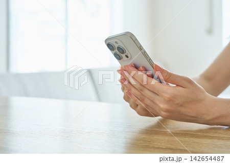 スマートフォンを持つ女性の手元 スマートフォンを持つ女性の手元 142654487