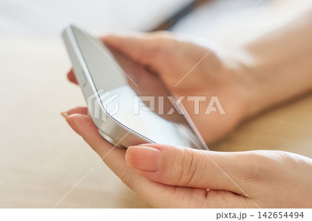 スマホを操作する女性の手元 スマホを操作する女性の手元 142654494