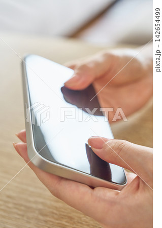 スマホを操作する女性の手元 スマホを操作する女性の手元 142654499