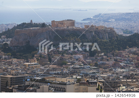 Athens, Attica, Greece, beautiful panoramic view of Athens cityscape, with The Parthenon, mountains, sea and scenery beyond the city, seen from Mount Lycabettus Hill observation deck in a sunny day Athens, Attica, Greece, beautiful panoramic view of Athens cityscape, with The Parthenon, mountains, sea and scenery beyond the city, seen from Mount Lycabettus Hill observation deck in a sunny day 142654916