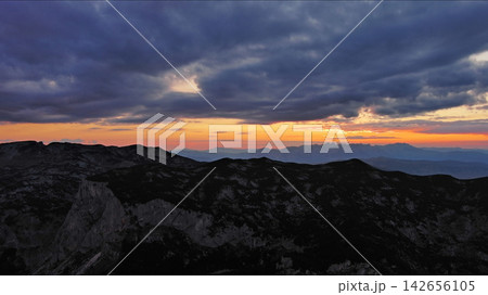 Sunset over mountain with dramatic clouds Sunset over mountain with dramatic clouds 142656105