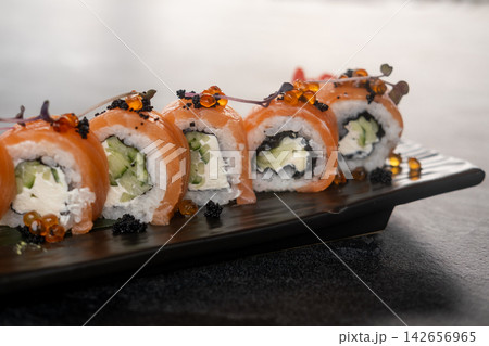 Sushi platter. Philadelphia set. Appetizing salmon roll row garnished with caviar micro sprouts. Asian menu restaurant gourmet meal. 142656965