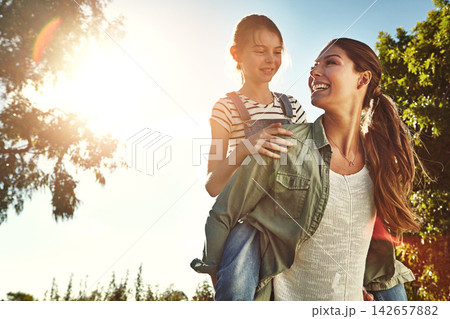 Sunshine, mom and child with piggyback in outdoor park for game, fun and bonding together. Nature, playing and happy mother with young girl on back for support, summer vacation or weekend in Indiana Sunshine, mom and child with piggyback in outdoor park for game, fun and bonding together. Nature, playing and happy mother with young girl on back for support, summer vacation or weekend in Indiana 142657882