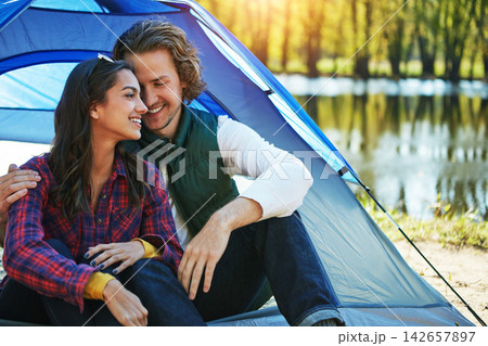 Camping, couple and hug in tent with love and happiness together on adventure in woods at lake. People, embrace or relax outdoor in countryside with peace on vacation or travel to river in forest 142657897
