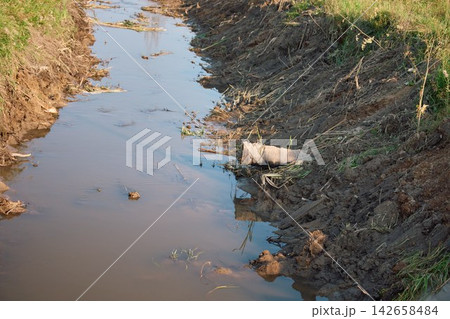 Industrial Drainage Sewage Pipes Discharging Wastewater into Canal 142658484