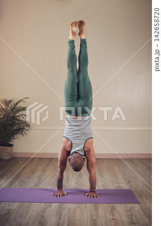 Man, yoga or hand stand in house for health, wellness or body flexibility for practice routine in studio. Chakra, zen yogi or strong person in pilates session for mindfulness, wellbeing or balance Man, yoga or hand stand in house for health, wellness or body flexibility for practice routine in studio. Chakra, zen yogi or strong person in pilates session for mindfulness, wellbeing or balance 142658720