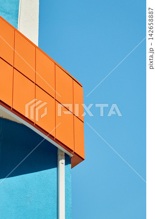 Vertical Minimalist Geometric Architecture Showing Bright Orange Panel Cladding and Blue Wall Vertical Minimalist Geometric Architecture Showing Bright Orange Panel Cladding and Blue Wall 142658887