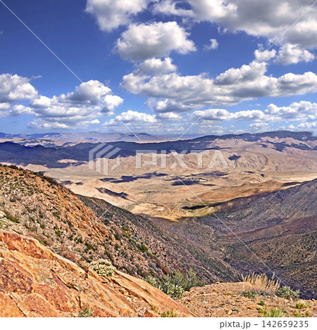 Blue sky, clouds and mountains with landscape for travel, scenery and hiking trail in environment. Sustainable, agriculture and plants on rocks in eco friendly and natural habitat in countryside. Blue sky, clouds and mountains with landscape for travel, scenery and hiking trail in environment. Sustainable, agriculture and plants on rocks in eco friendly and natural habitat in countryside. 142659235
