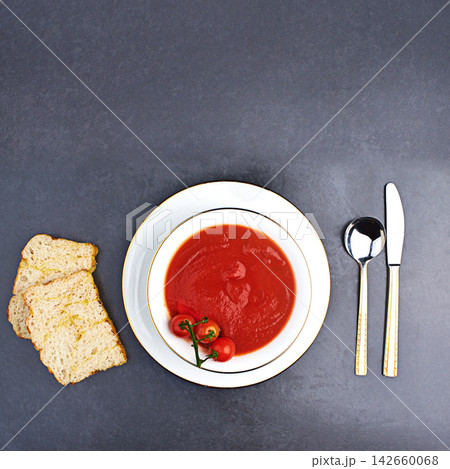 Tomato, soup and bread on menu in restaurant with bowl of healthy food, spoon and knife on table. Dinner, dish or luxury appetizer course in fine dining kitchen with vegetables for nutrition in diet Tomato, soup and bread on menu in restaurant with bowl of healthy food, spoon and knife on table. Dinner, dish or luxury appetizer course in fine dining kitchen with vegetables for nutrition in diet 142660068