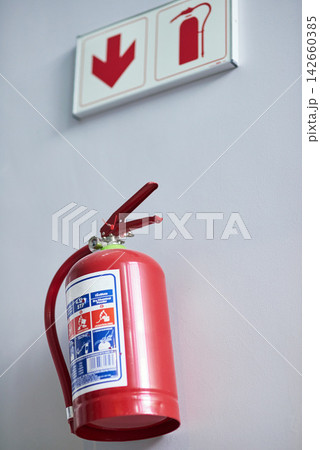 Fire extinguisher, wall and sign for firefighting, action and safety with emergency help and support. Portable dry and chemical powder to stop flame, air and oxygen for building equipment and arrow Fire extinguisher, wall and sign for firefighting, action and safety with emergency help and support. Portable dry and chemical powder to stop flame, air and oxygen for building equipment and arrow 142660385