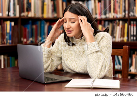 College, laptop or woman with stress headache at campus library for research, planning or homework burnout. University, depression or student frustrated by exam deadline, anxiety or pc glitch or 404 College, laptop or woman with stress headache at campus library for research, planning or homework burnout. University, depression or student frustrated by exam deadline, anxiety or pc glitch or 404 142660460