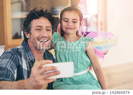Happy father, daughter and bonding with selfie on sofa for photography, picture or memory together at home. Little girl and dad with smile or costume for capture, moment or childhood in living room 142660874