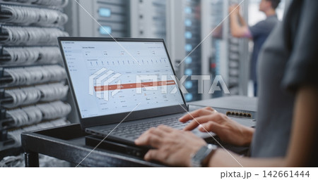 Female Engineer Responding to Critical Server Overheating Alert in Data Center 142661444